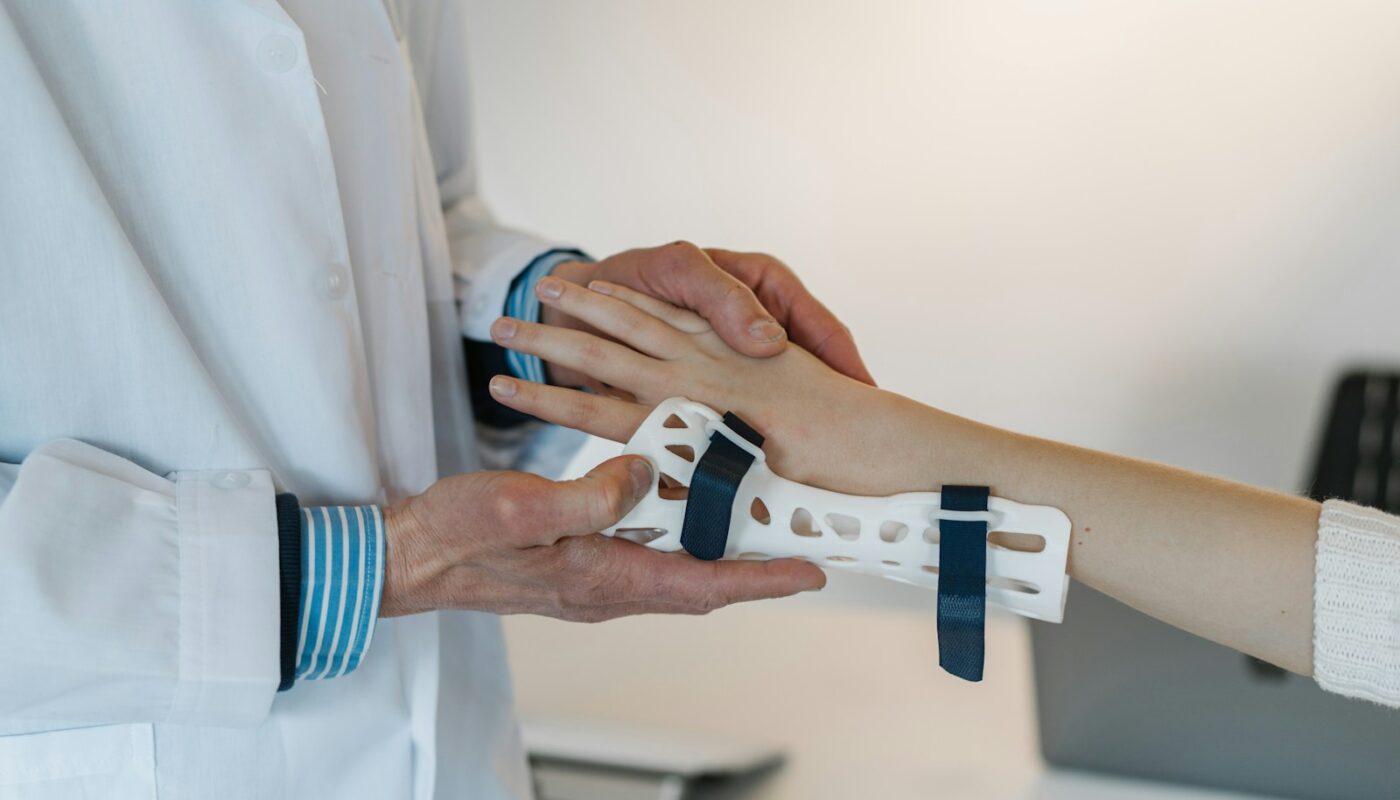 person in white coat holding silver and blue ring