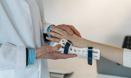 person in white coat holding silver and blue ring